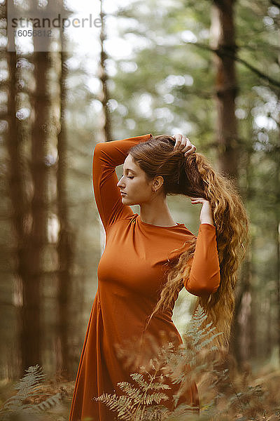 Schöne Frau mit langen blonden Haaren im Wald stehend