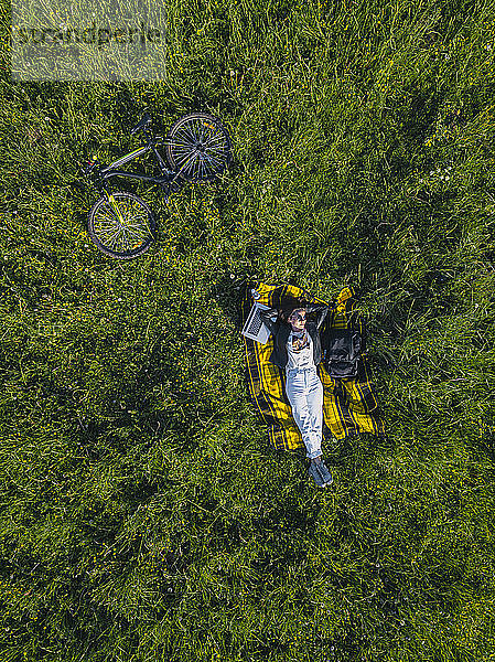 Frau im Gras liegend  Luftaufnahme