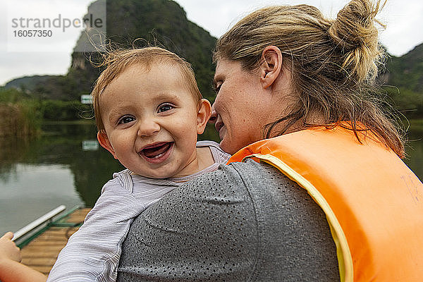 Vietnam  Mutter mit Baby im Boot bei Trang An Scenic Landscape Complex