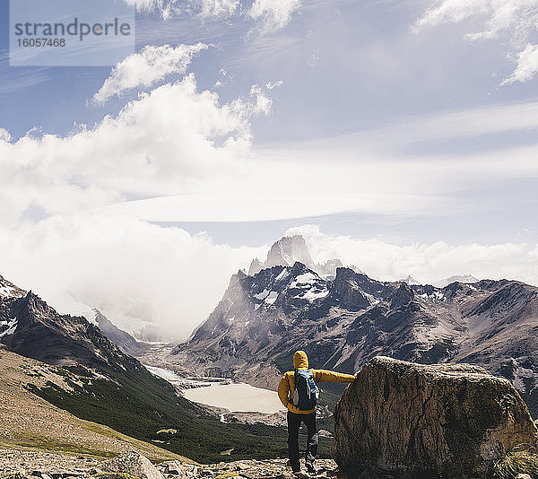 Mann mit Rucksack schaut auf schneebedeckten Berg gegen Himmel  Patagonien  Argentinien