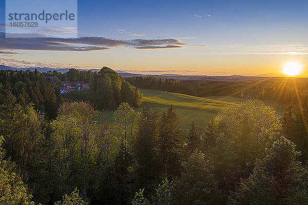 Deutschland  Bayern  Bad Heilbrunn  Drohnenansicht einer grünen Landschaft bei Sonnenuntergang