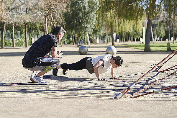 Frau beim Workout mit Trainer im Park