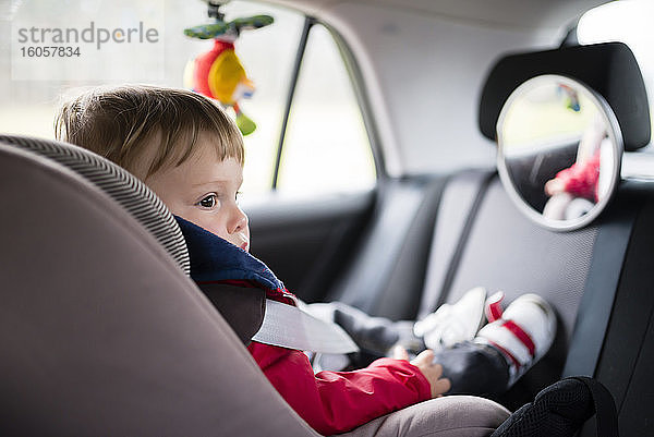 Babyjunge schaut weg  während er auf dem Autositz sitzt