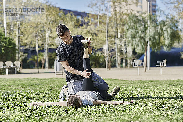 Frau beim Workout mit Trainer im Park