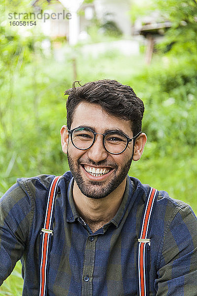 Porträt eines lachenden jungen Mannes mit Brille