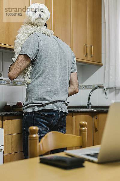 Mann mit Hund beim Kochen in der Küche