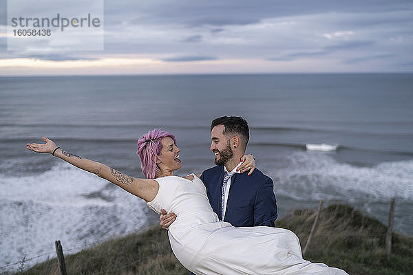 Brautpaar auf Aussichtspunkt und Meer im Hintergrund