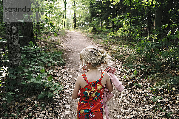 Mädchen beim Wandern inmitten von Bäumen im Wald
