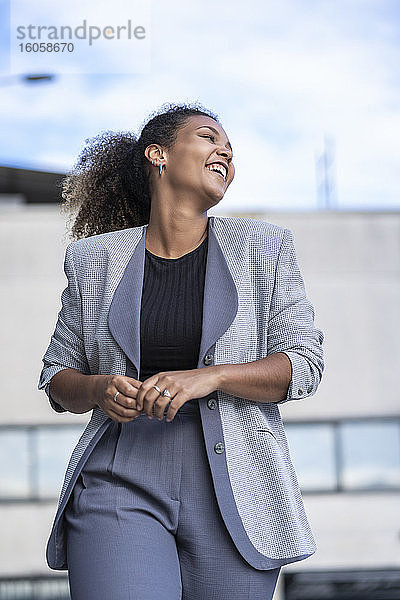 Lächelnde Geschäftsfrau vor einem Bürogebäude