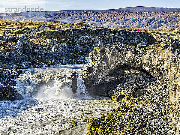 Wasserfall und Fluss  die durch zerklüftetes Gelände fließen  mit Touristen auf einem Pfad zur Besichtigung; Thingeyjarsveit  Nordost-Region  Island