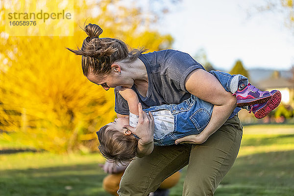 Eine Mutter spielt mit ihrer Kleinkind-Tochter in einem Park mit Herbstfarben; North Vancouver  British Columbia  Kanada
