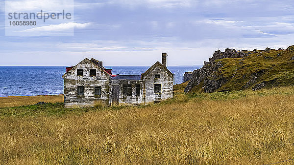 Ein verwittertes und verlassenes Haus an der Küste; Island