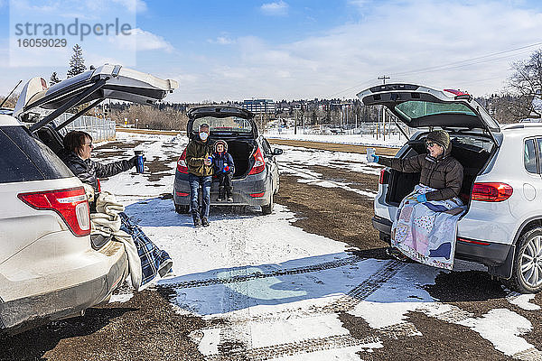 Familien sitzen hinten in ihren Fahrzeugen auf einem Parkplatz  den sie während der Weltpandemie Covid-19 besuchen; St. Albert  Alberta  Kanada