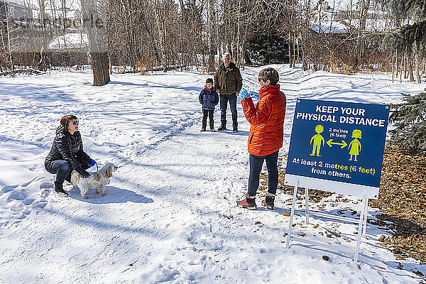 Familien werden auf einem Weg durch einen Park während der Weltpandemie Covid-19 aus der Ferne besucht; St. Albert  Alberta  Kanada