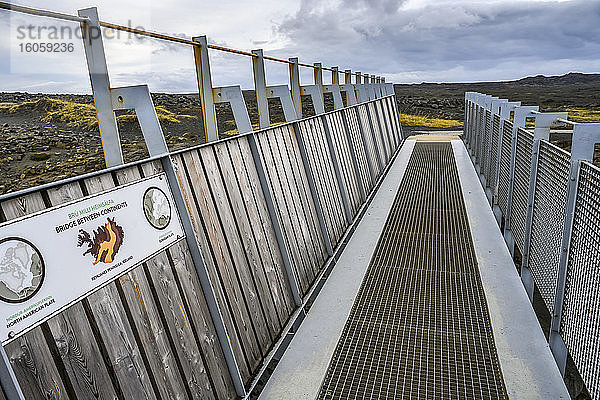 Ein Metallsteg mit Schild für die 'Brücke zwischen den Kontinenten'  zwischen der nordamerikanischen und der eurasischen Platte; Reykjanesbaer  südliche Halbinselregion  Island