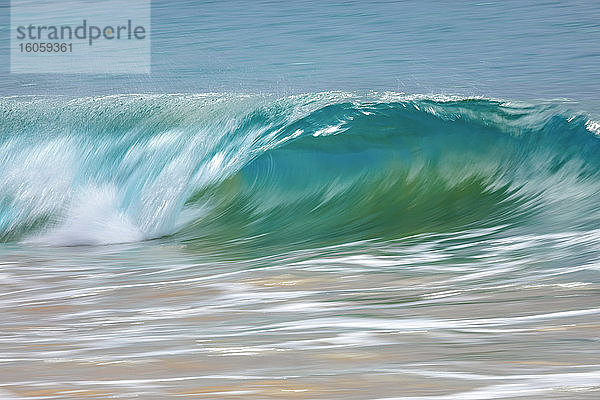 Bewegungsunschärfe der blauen rollenden Wellen  die in den goldenen Sand am Ufer rollen; Kihei  Maui  Hawaii  Vereinigte Staaten von Amerika