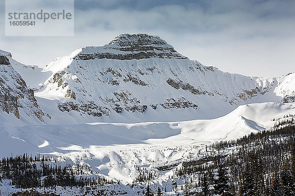 Nahaufnahme eines schneebedeckten Berggipfels mit Gletscher und dunstigem blauen Himmel  Banff National Park; Lake Louise  Alberta  Kanada