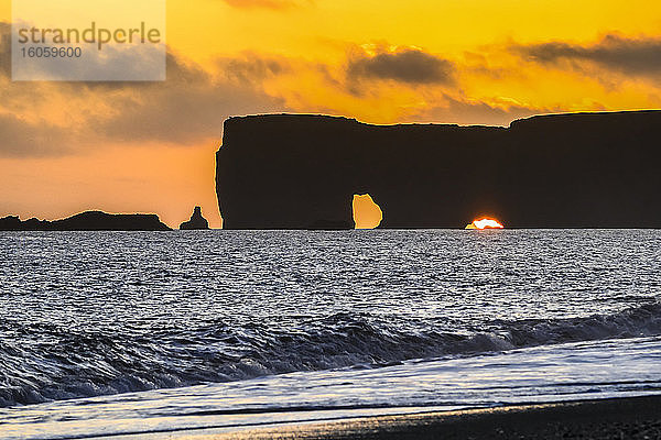 Reynisfjara  Basaltgesteinsformationen vor der Küste und ein schwarzer Sandstrand bei Sonnenuntergang; Myrdalshreppur  Südliche Region  Island