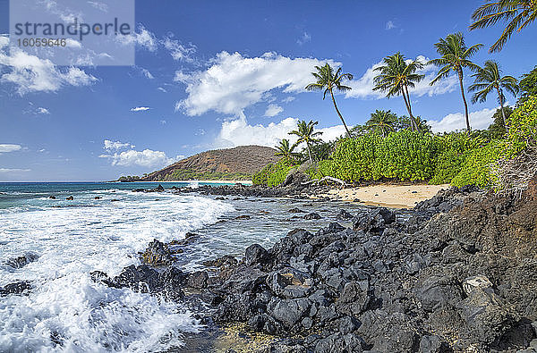 Küstenlinie von Maui mit schroffem Lavagestein und Palmen und einem kleinen abgelegenen Strand; Kihei  Maui  Hawaii  Vereinigte Staaten von Amerika