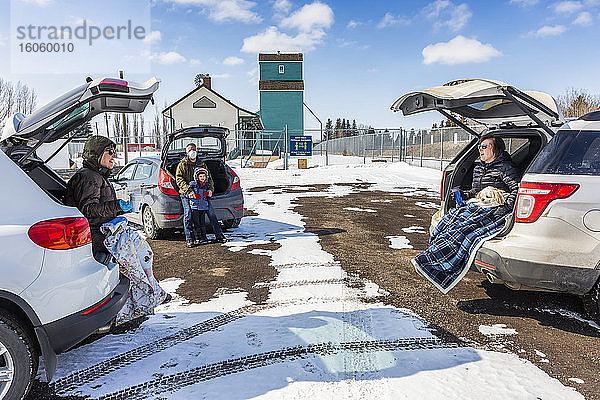 Familien sitzen hinten in ihren Fahrzeugen auf einem Parkplatz  den sie während der Weltpandemie Covid-19 besuchen; St. Albert  Alberta  Kanada