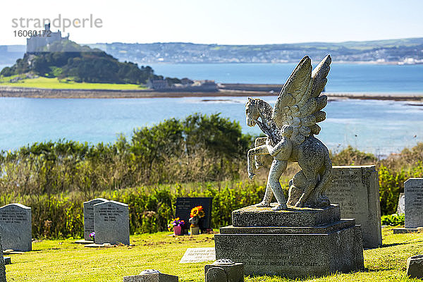 Aufwändiger steinerner Grabstein eines geflügelten Pferdes und Männchens auf einem Friedhof mit einer Insel und dem Schloss von St. Michael im Hintergrund; Grafschaft Cornwall  England