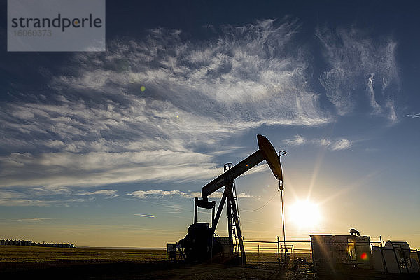 Silhouette eines Pumpjack mit Sonnenaufgang bei Sonnenaufgang  westlich von Airdrie; Alberta  Kanada