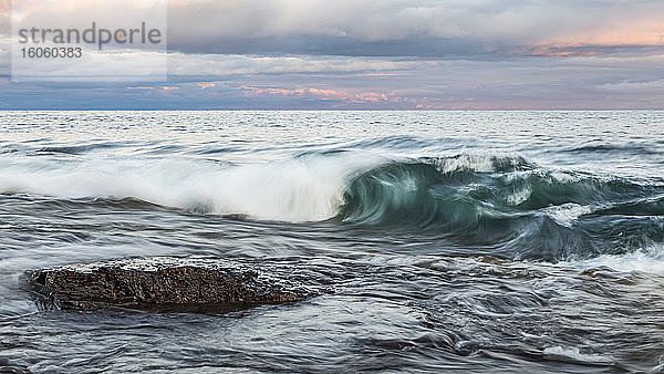 Lake Superior bei Sonnenuntergang mit großen Wellen  die ans Ufer rollen; Minnesota  Vereinigte Staaten von Amerika