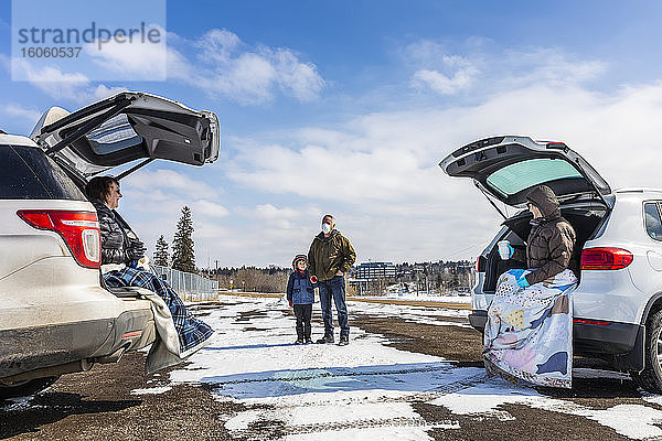 Familien sitzen hinten in ihren Fahrzeugen auf einem Parkplatz  den sie während der Weltpandemie Covid-19 besuchen; St. Albert  Alberta  Kanada