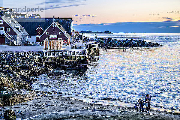 Eine junge Familie am Strand am Ufer von Nuuk in der Abenddämmerung; Nuuk  Sermersooq  Grönland