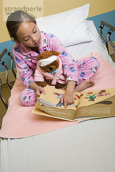 Ein junges Mädchen liest eine Geschichte im Krankenhausbett; Alberta  Kanada