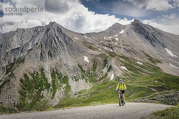 Mountainbikerin fährt auf alpiner Schotterstraße  Serfaus  Tirol  Österreich  Europa