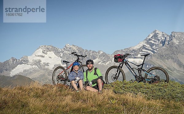 Mountainbikerpaar sitzt neben eBikes in herbstlicher Bergkulisse der Stubaier Alpen  Freizeitarena Bergeralm  Bikepark Tirol  Gries am Brenner  Tirol  Österreich  Europa
