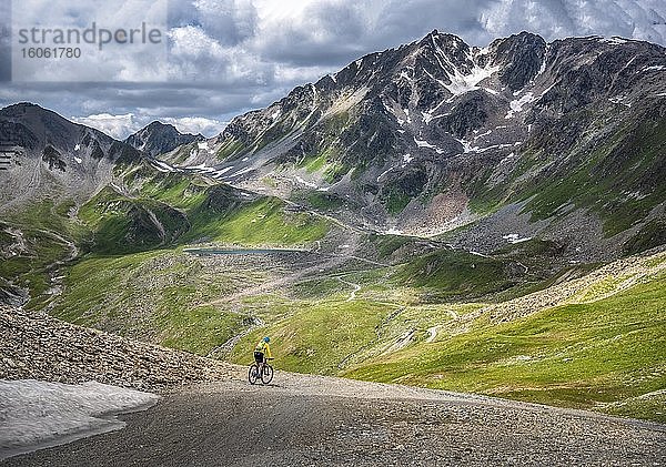 Mountainbikerin  Anfang fünfzig fährt auf alpiner Schotterstraße im Hochgebirge  Serfaus  Tirol  Österreich  Europa