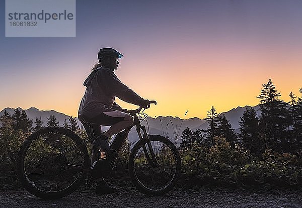 Silhoutte einer Mountainbikerin in Abenddämmerung  hinten Bergkulisse  Patscherkofel  Patsch  Tirol  Österreich  Europa