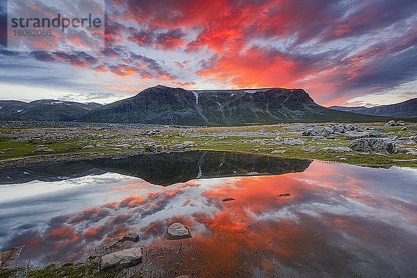 Bergkette spiegelt sich im See in Abendstimmung mit roten Wolken  Gällivare  Norrbottens län  Schweden  Europa