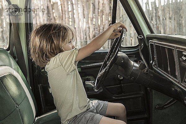 5-jähriger Junge am Steuer eines Pick-up TruckNM aus den 1970er Jahren.