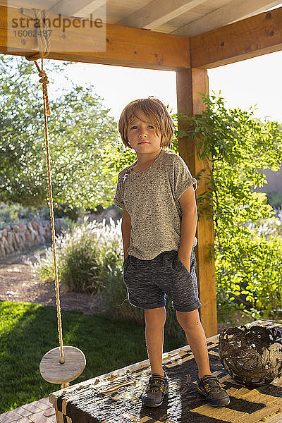 Porträt eines 4 Jahre alten Jungen auf seiner Veranda