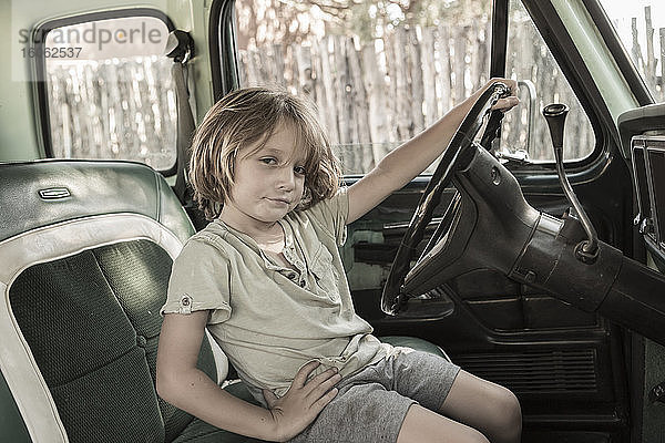 5-jähriger Junge am Steuer eines Pick-up TruckNM aus den 1970er Jahren.