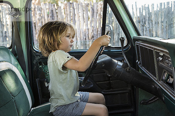 5-jähriger Junge am Steuer eines Pick-up TruckNM aus den 1970er Jahren.