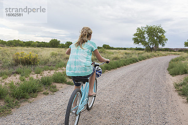 Rückansicht eines 11-jährigen Mädchens beim Radfahren auf der Landstraße