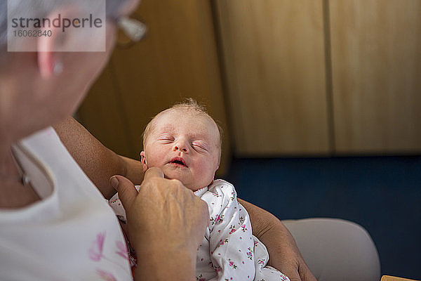 Eine Frau hält ein schlafendes Neugeborenes