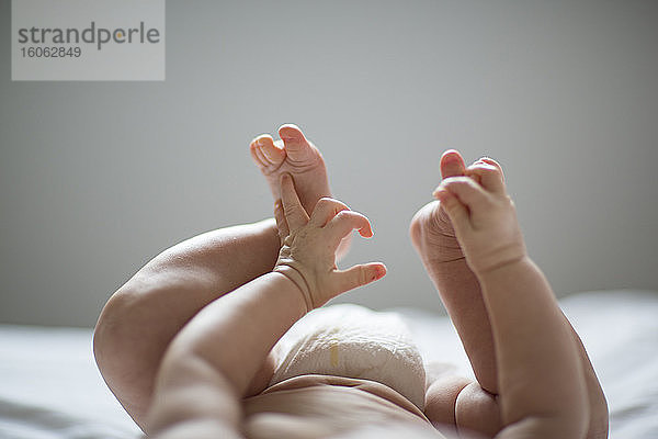 Beine und Hände eines auf dem Rücken liegenden Babys