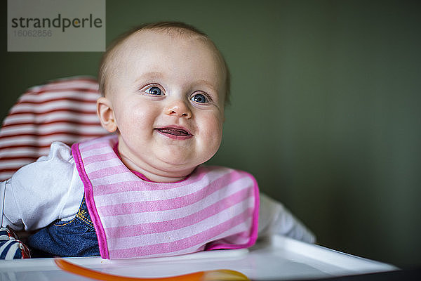 Porträt eines lächelnden Babys im Hochstuhl