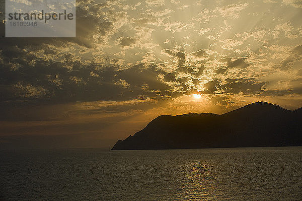 Europa  Italien  Ligurien  Ligurisch. Spektakulärer Sonnenuntergang mit Wolken über Punta Mesco in den Cinque Terre des ligurischen Meeres.