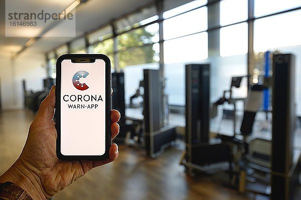 Hand hält Smartphone mit Corona Warn-APP im Fitness-Center  Corona-Krise  Stuttgart  Baden-Württemberg  Deutschland  Europa