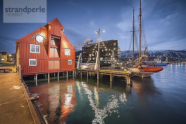 Polarmuseum am Hafen mit Spiegelung im Meer in Abenddämmerung  Polarnacht  Tromsö  Troms  Norwegen  Europa