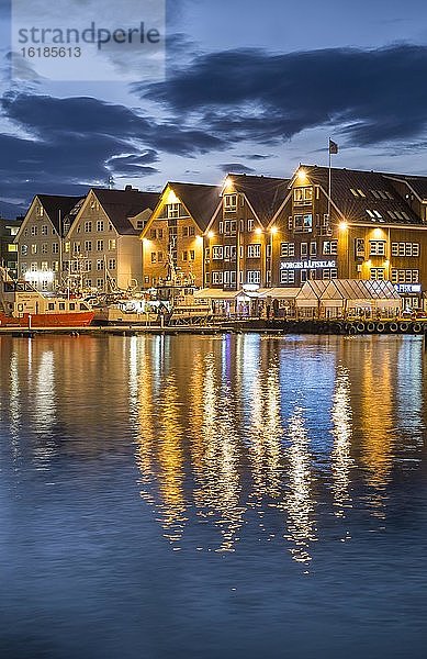 Beleuchtete Häuserzeile am Hafen mit Spiegelungim Meer  Polarnacht  Tromsö  Troms  Norwegen  Europa