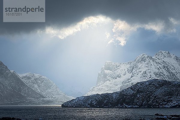 Dramatische Lichtstimmung in den Wolken über dem winterlichen Meer  Berge  Vesteralen  Hovden  Nordland  Norwegen  Europa