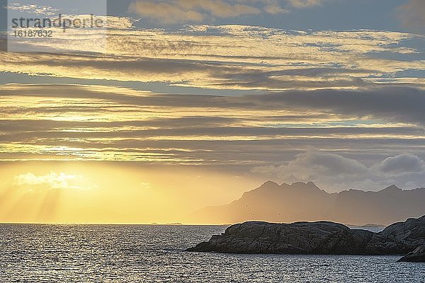 Sonnenuntergang mit goldener Lichtstimmung ober dem Meer  hinten Lofotengipfel  Kleppstad  Lofoten  Nordland  Norwegen  Europa