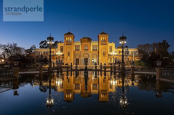 Beleuchtetes Kunstmuseum Museo de Artes y Costumbres Populares de Sevilla spiegelt sich in einem Brunnen  blaue Stunde  Plaza de America  Sevilla  Andalusien  Spanien  Europa